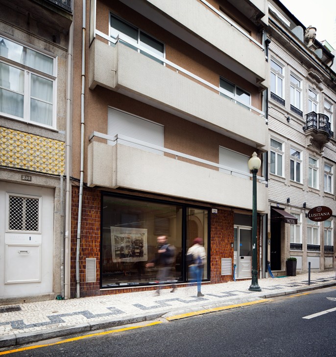 Exterior storefront of EarlyMade retail shop in Porto with brick facade and large windows.