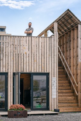 Martin Thim stands on the renovated coal bridge structure in Aarhus, Denmark, featuring wooden architecture and modern design elements.