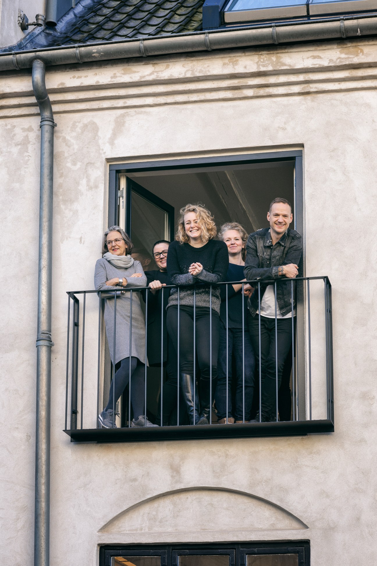 Five members of the Vipp team stand together on a balcony of a Copenhagen building.