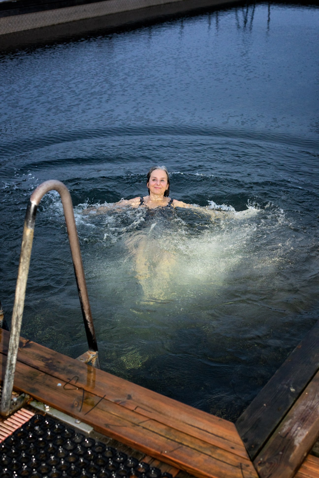 Woman swimming in a canal in Copenhagen during winter, part of her year-round daily ritual.