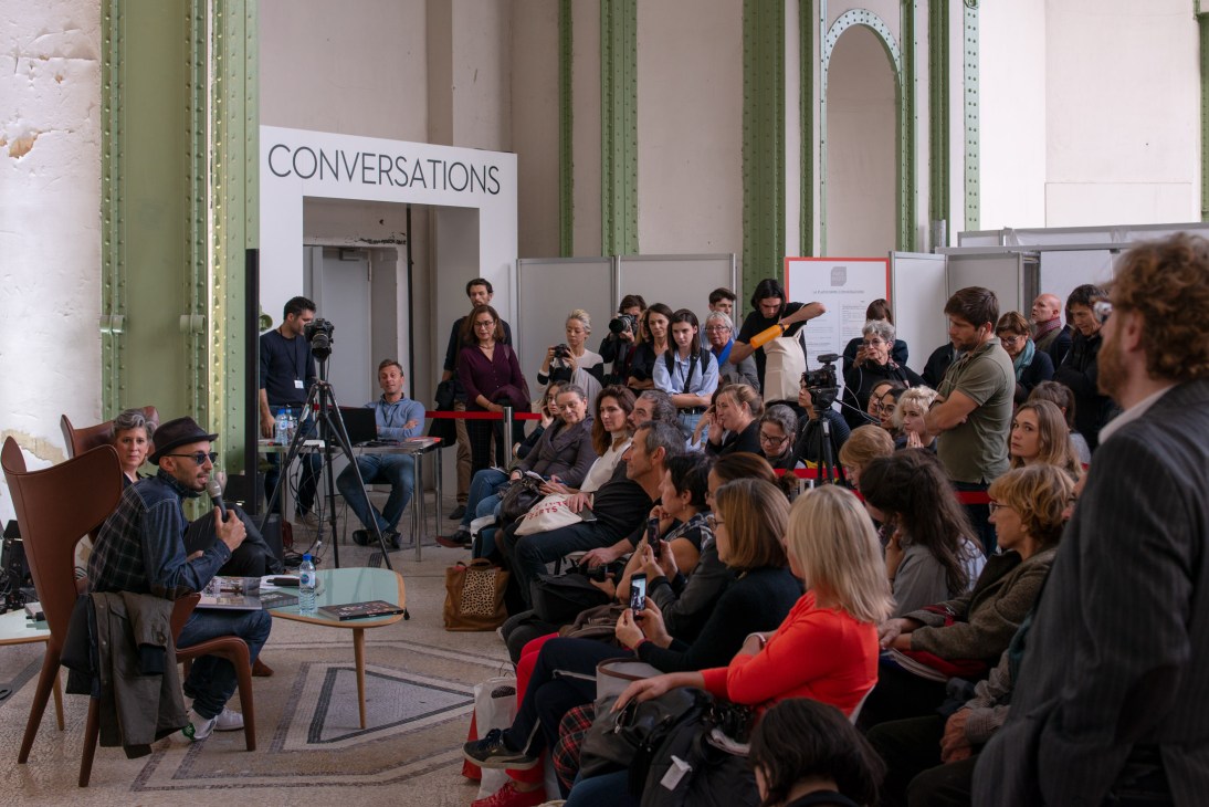 Crowd gathered at Paris Photo to hear French photographer JR speak at The Artist Talks series in the Grand Palais.