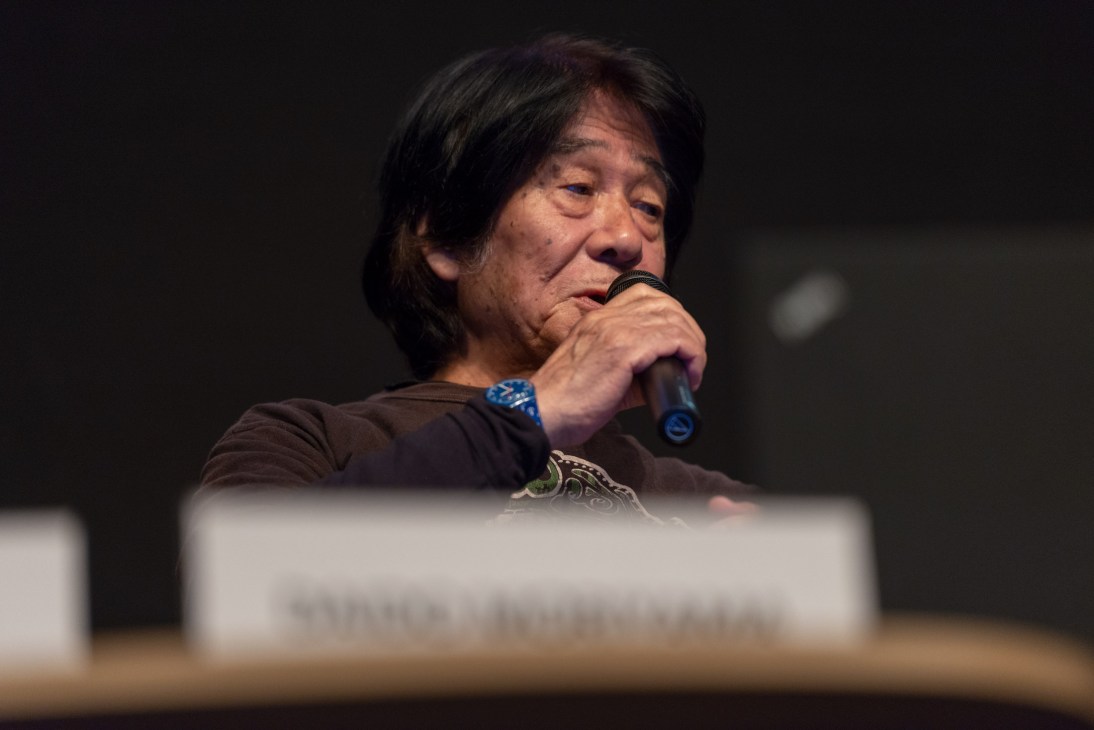 Pioneering Japanese photographer Daido Moriyama speaking into a microphone at Paris Photo.