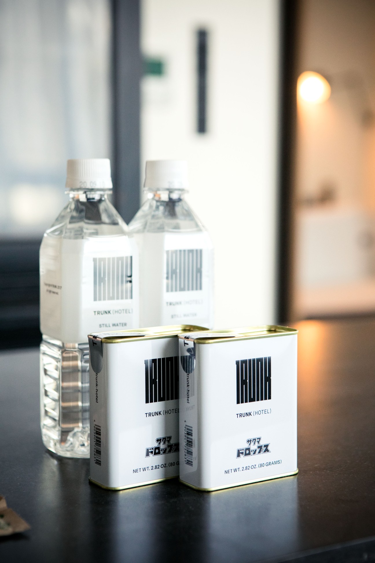 Trunk Hotel minibar products including water bottles and tea boxes displayed on dark surface