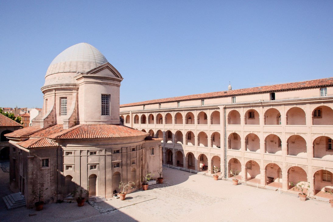 Sun-drenched courtyard with terracotta arches at La Vieille Charité in Le Panier, Marseille.