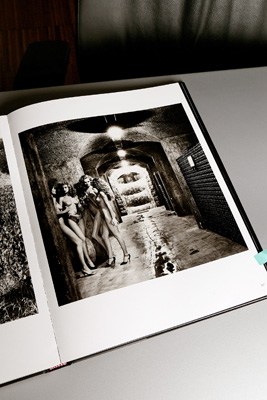 A black and white photograph by Helmut Newton displayed on a table.