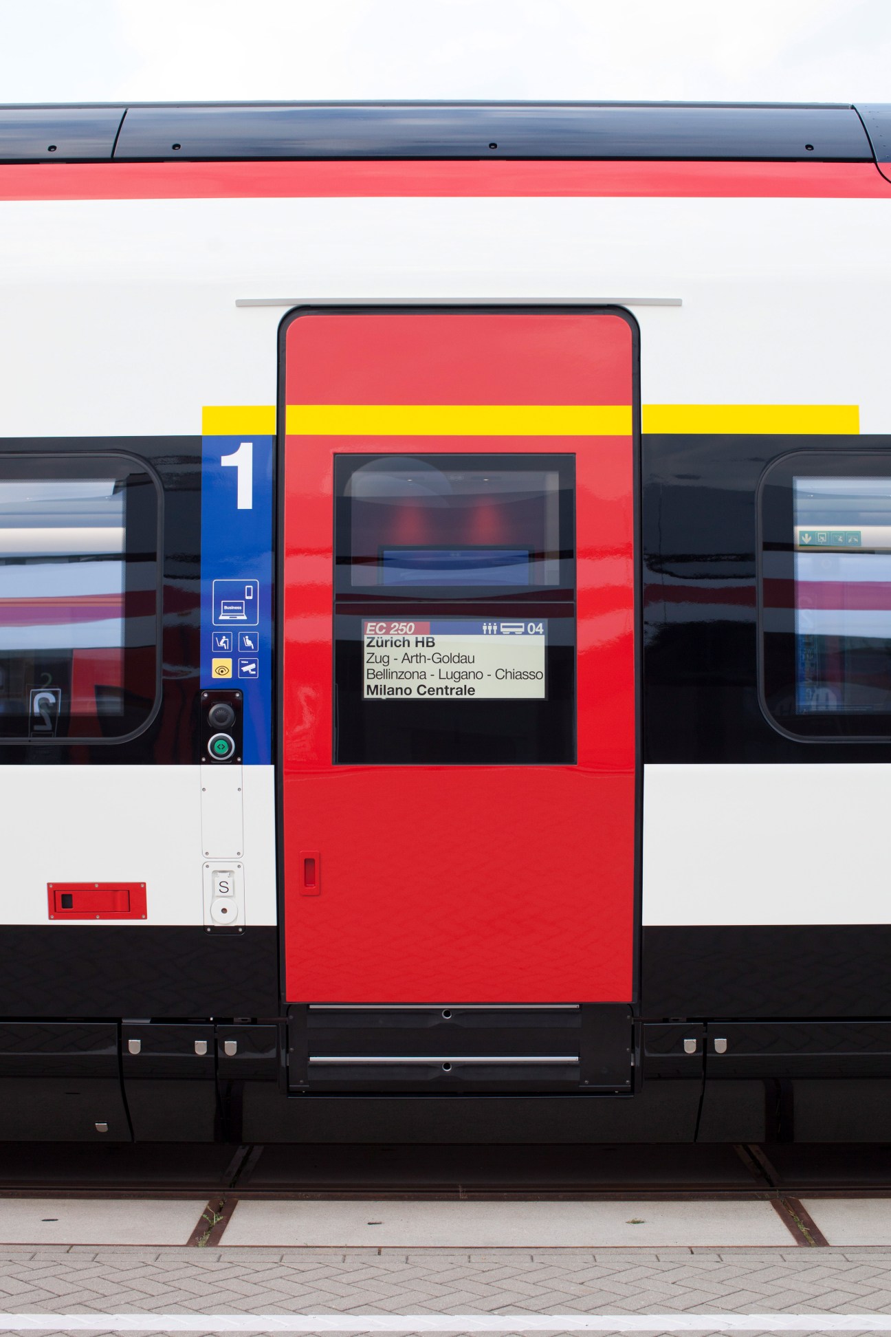Close-up of EC250 Giruno train door and side panel in red and white with blue accessibility symbols