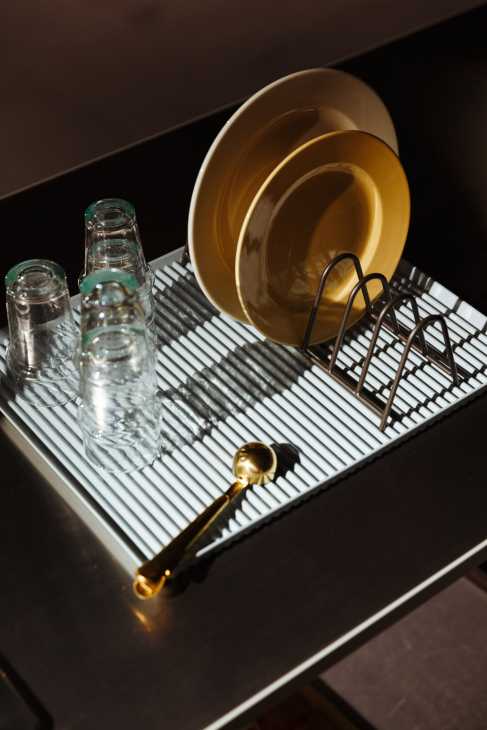 Hay Tokyo store interior showing gold bowls, glasses, and tableware on a white ribbed surface