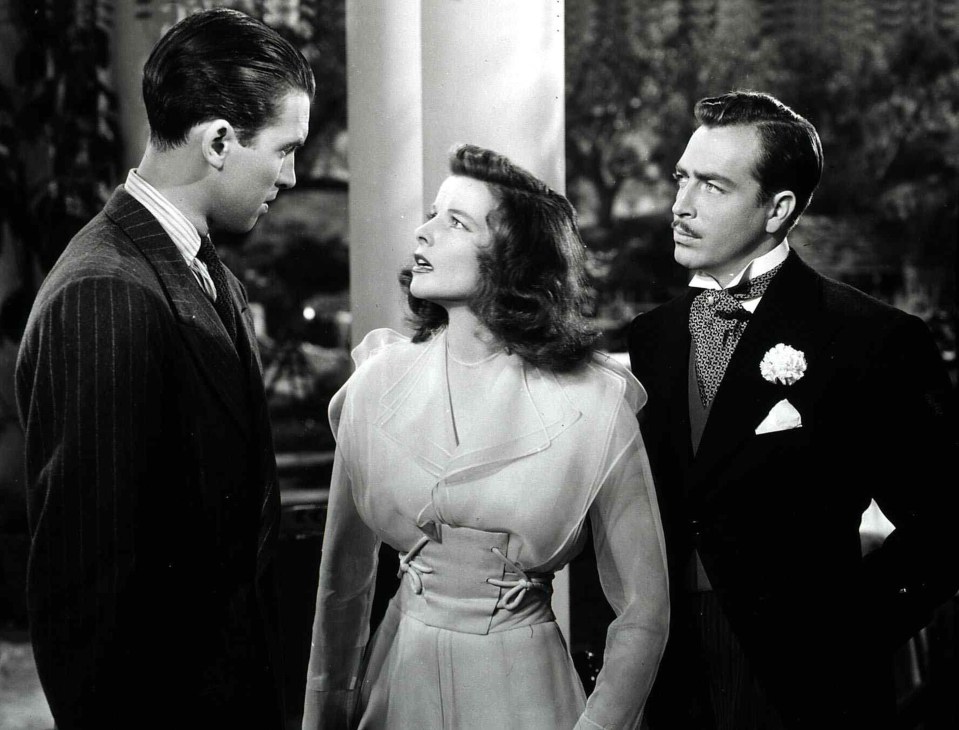 Black and white film still from The Philadelphia Story showing three actors in formal 1940s attire.