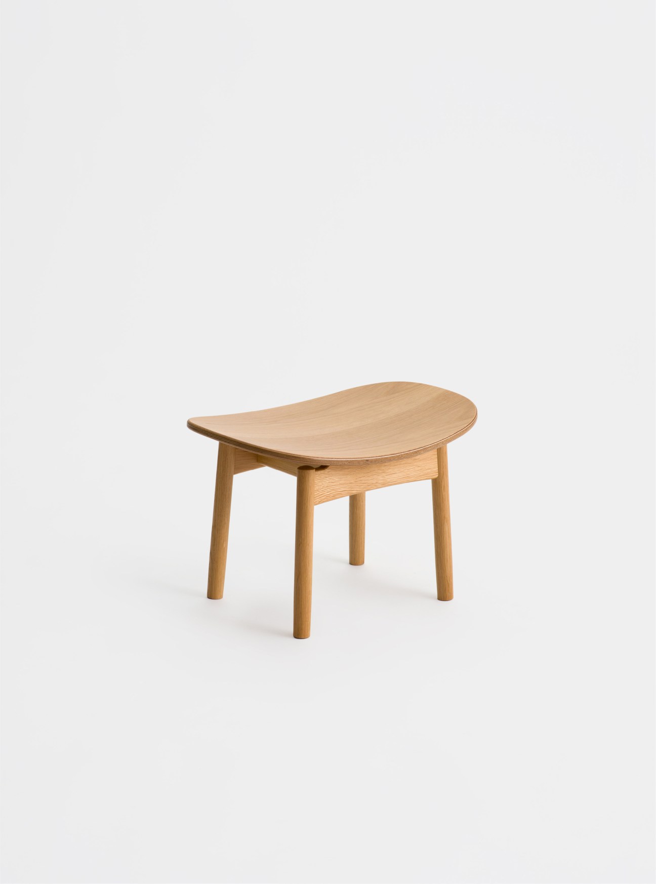 Light oak wooden stool with curved seat and four cylindrical legs on white background.