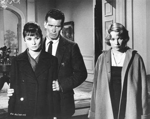 Black and white film still from The Children's Hour showing three actors in 1960s attire in an elegant interior setting.