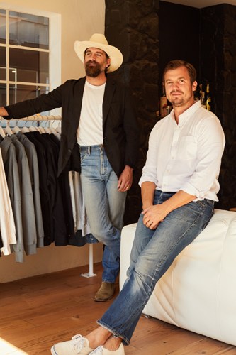 Buck Mason founders Erik Allen and Sasha Koehn in their LA shop, examining a hoodie.