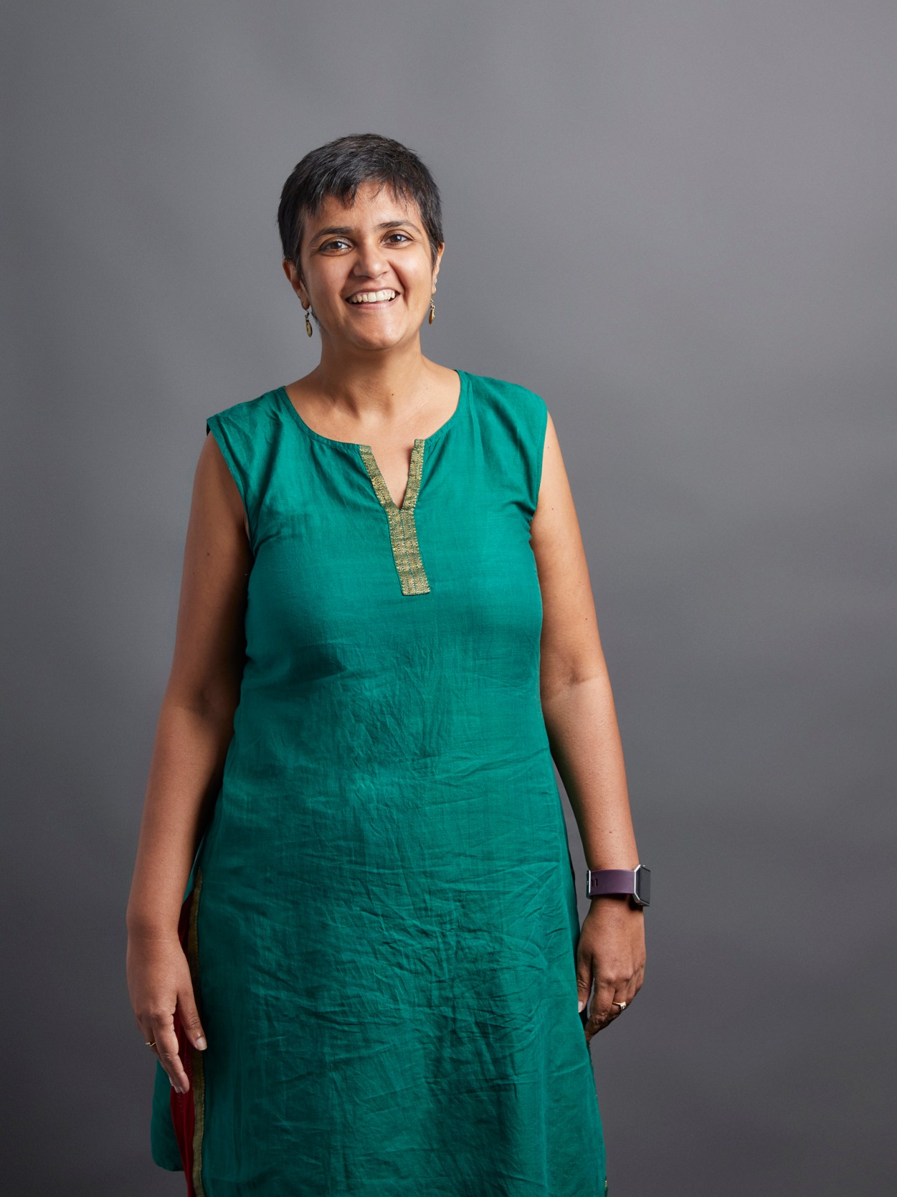 Portrait of Neelam Raaj, Editor of Sunday Times, smiling in a teal sleeveless dress.
