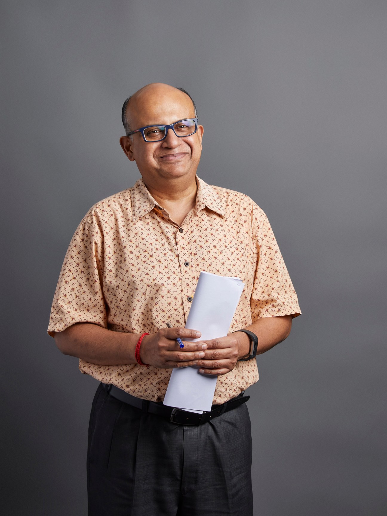 Subhendu Mukherjee, city editor for Delhi, holding a document and wearing glasses.