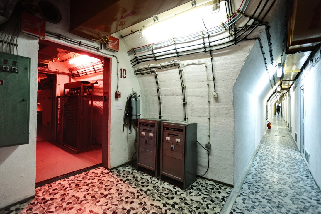 Interior of Atomska Ratna Komanda (Ark), a former Yugoslav nuclear bunker with red-lit corridor and electrical infrastructure.