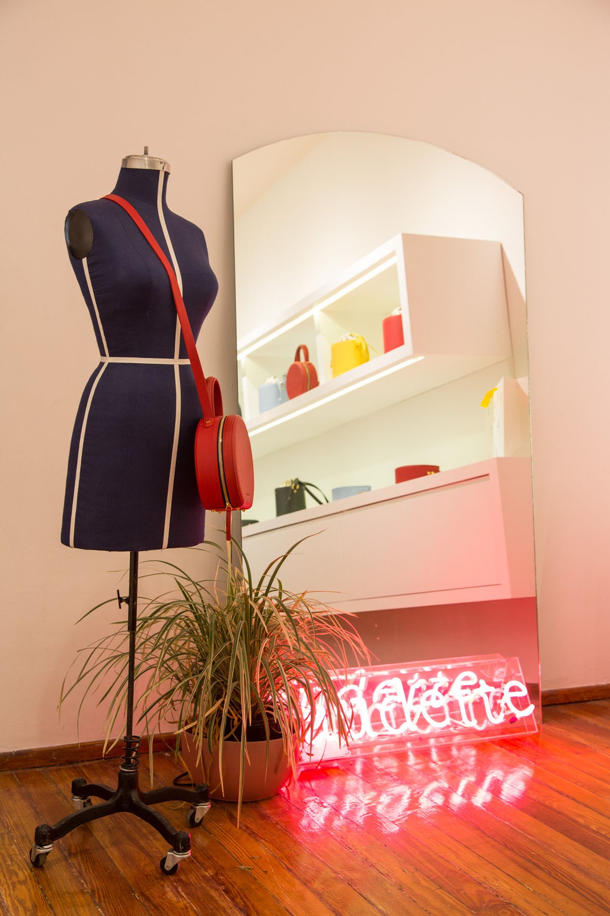 Audette shop interior with dress form, red handbag, mirror, and neon sign in Mexico City.