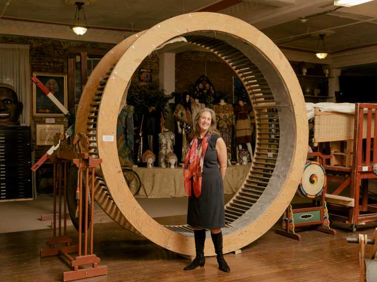 Laura Callanan stands inside a large wooden circular structure at Upstart Co-Lab gallery.
