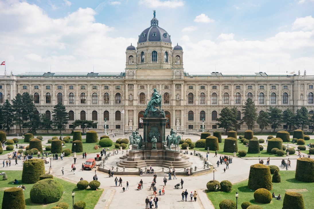 Vienna's historic museum building with dome and statue in manicured public square.