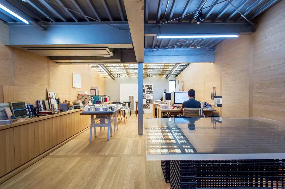 Daikei Mills office interior with white oak paneling, exposed steel beams, and natural light from industrial ceiling.