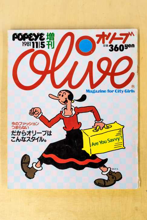 Olive magazine cover from 1981 featuring the Olive Oyl character in red dress holding a yellow bag with retro typography design.