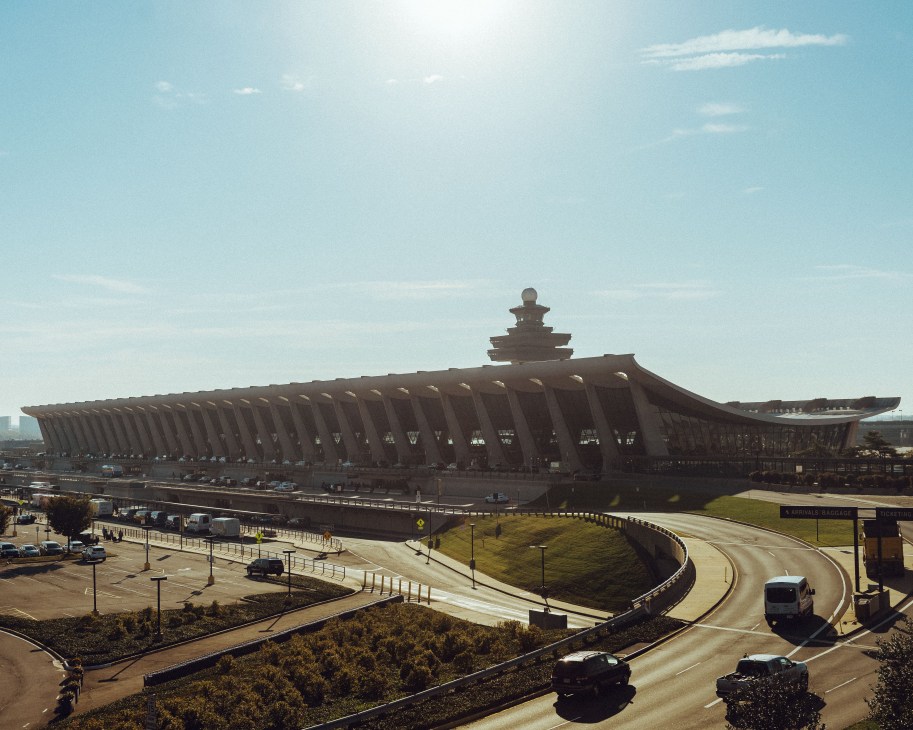 Dulles International Airport terminal building with distinctive curved roof design and surrounding landscape.