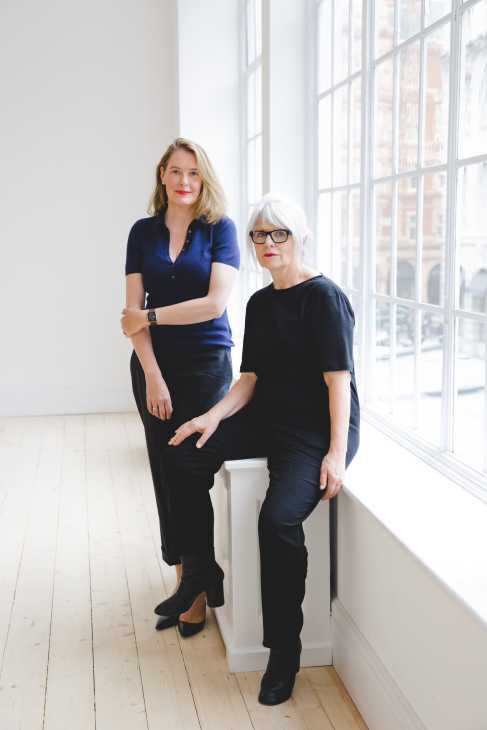 Monika Sprüth and Philomene Magers, gallerists, pose together by a large window in their London gallery space.