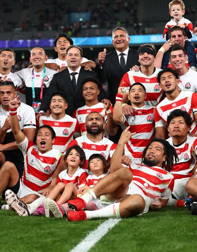 Japan's rugby team celebrates together on the field after a World Cup match