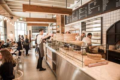 Interior of The Lebanese Bakery in London showing counter service with staff and customers