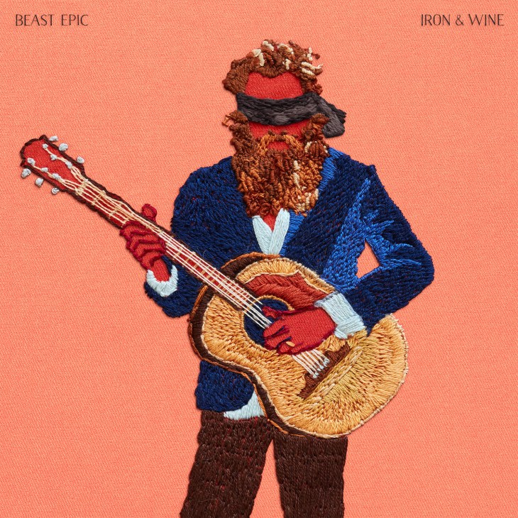 Embroidered illustration of a bearded musician playing guitar wearing a blue jacket and red mask.