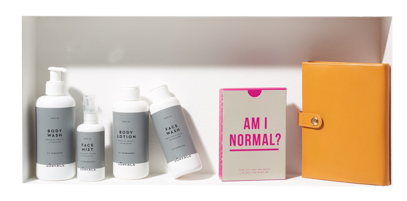 Sûrface skincare bottles, School of Life card game box, and Ettinger leather notepad holder displayed together.