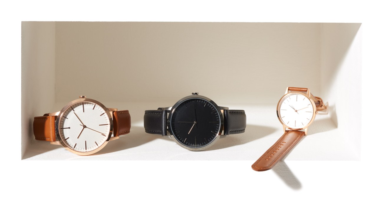 Three Freedom to Exist watches with minimalist designs, featuring leather straps in brown and black with clean white and black faces.