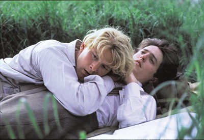 Two men lying in grass, scene from the film Maurice directed by James Ivory.