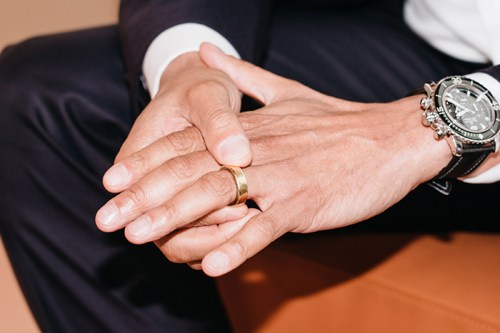 Hands displaying a wedding ring, symbolizing marriage and family foundation.