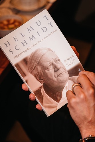A biography book about Helmut Schmidt held in someone's hands.