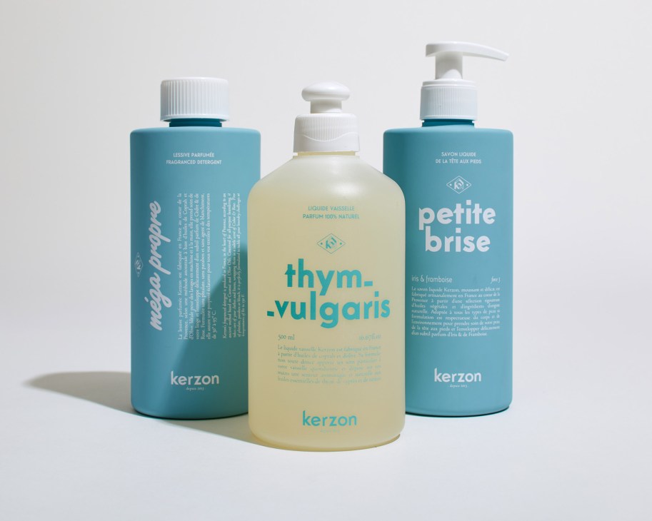 Three Kerzon cleaning products with teal and cream colored bottles against a white background.