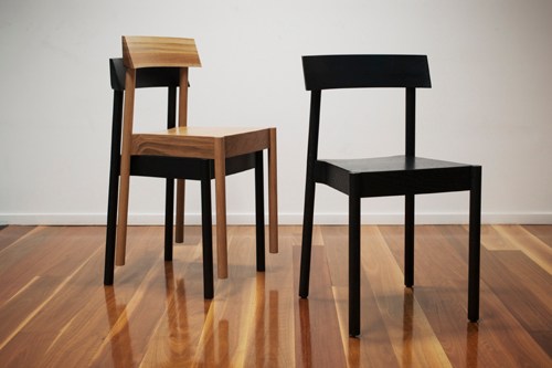 Two wooden chairs in light and dark finishes displayed on wooden flooring.