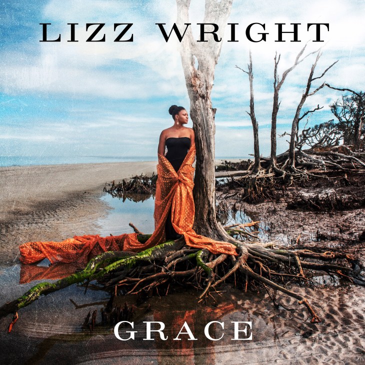 Album cover for Lizz Wright's Grace featuring a woman in an orange shawl standing by dead trees on a beach.