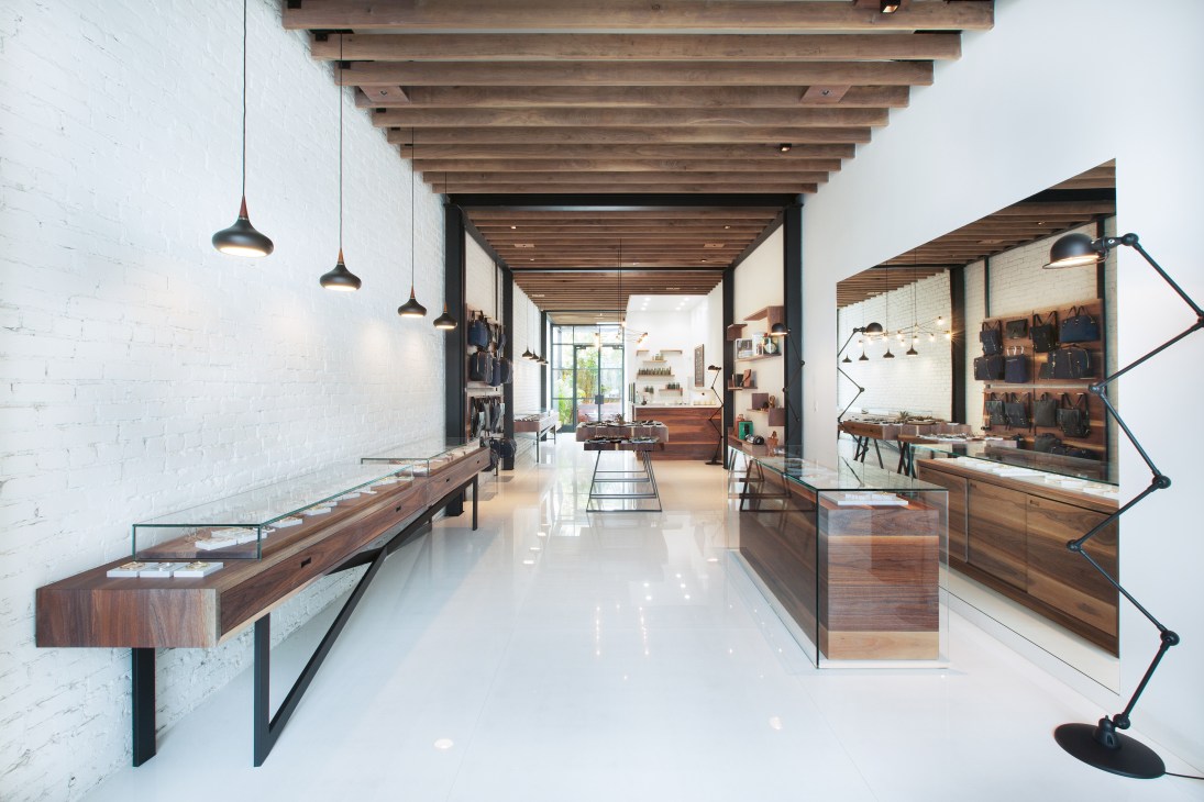 Interior of Miansai showroom in Venice Beach with wooden display cases and pendant lighting.