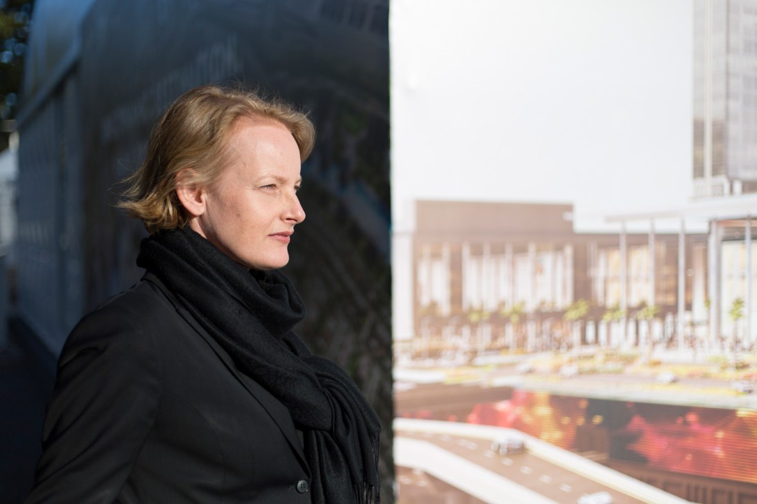 Alexandra Hagen, CEO of White Arkitekter, in profile wearing a black coat against an urban backdrop.