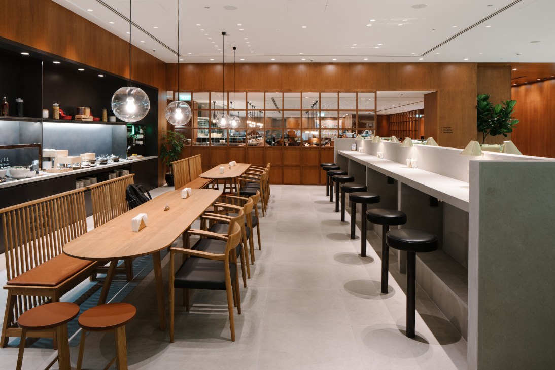 Cathay Pacific lounge at Singapore's Terminal 4 with cherry wood paneling, teardrop design, and dining counter.