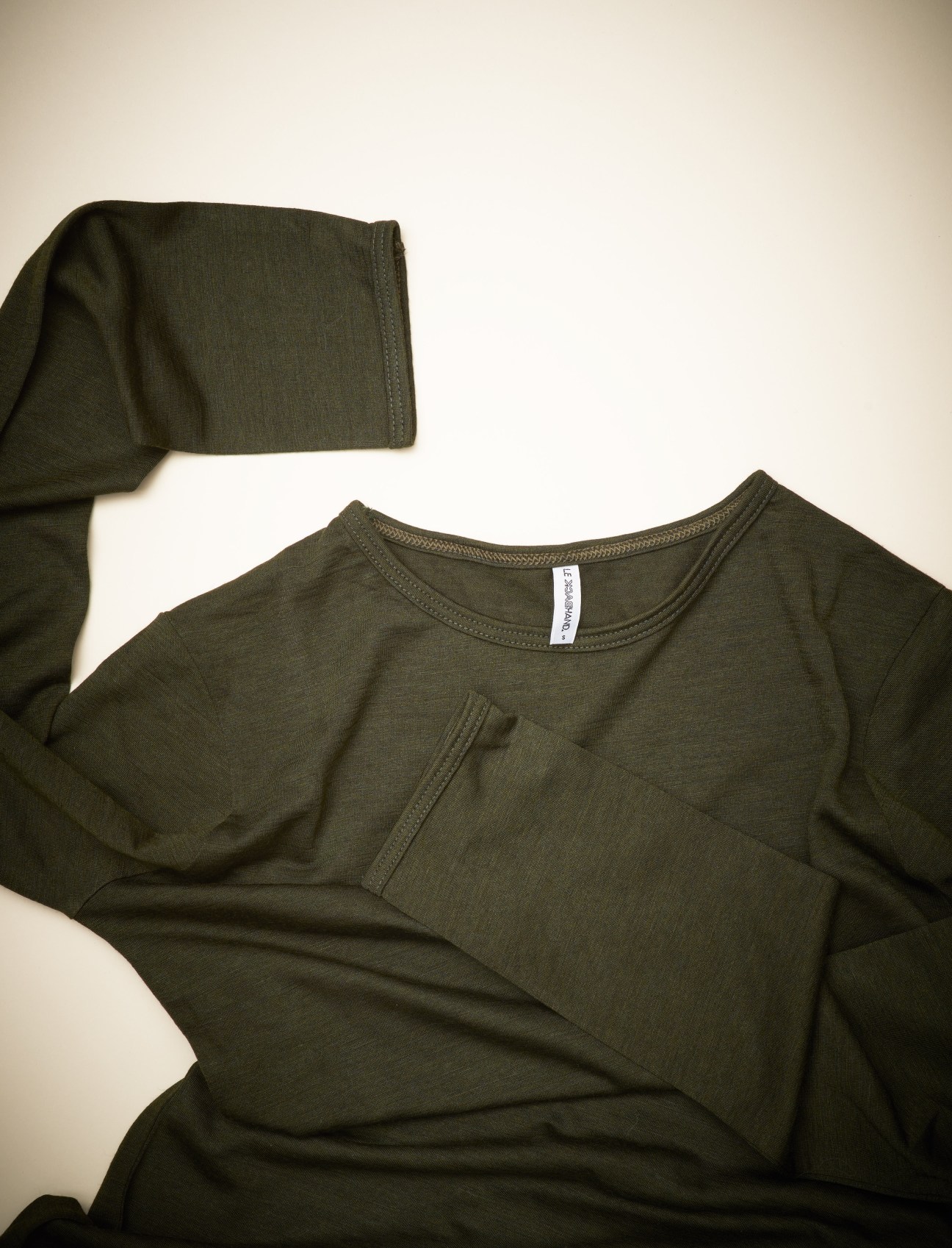 Olive-green merino wool and silk undergarments from La Backhand laid flat on a neutral background.