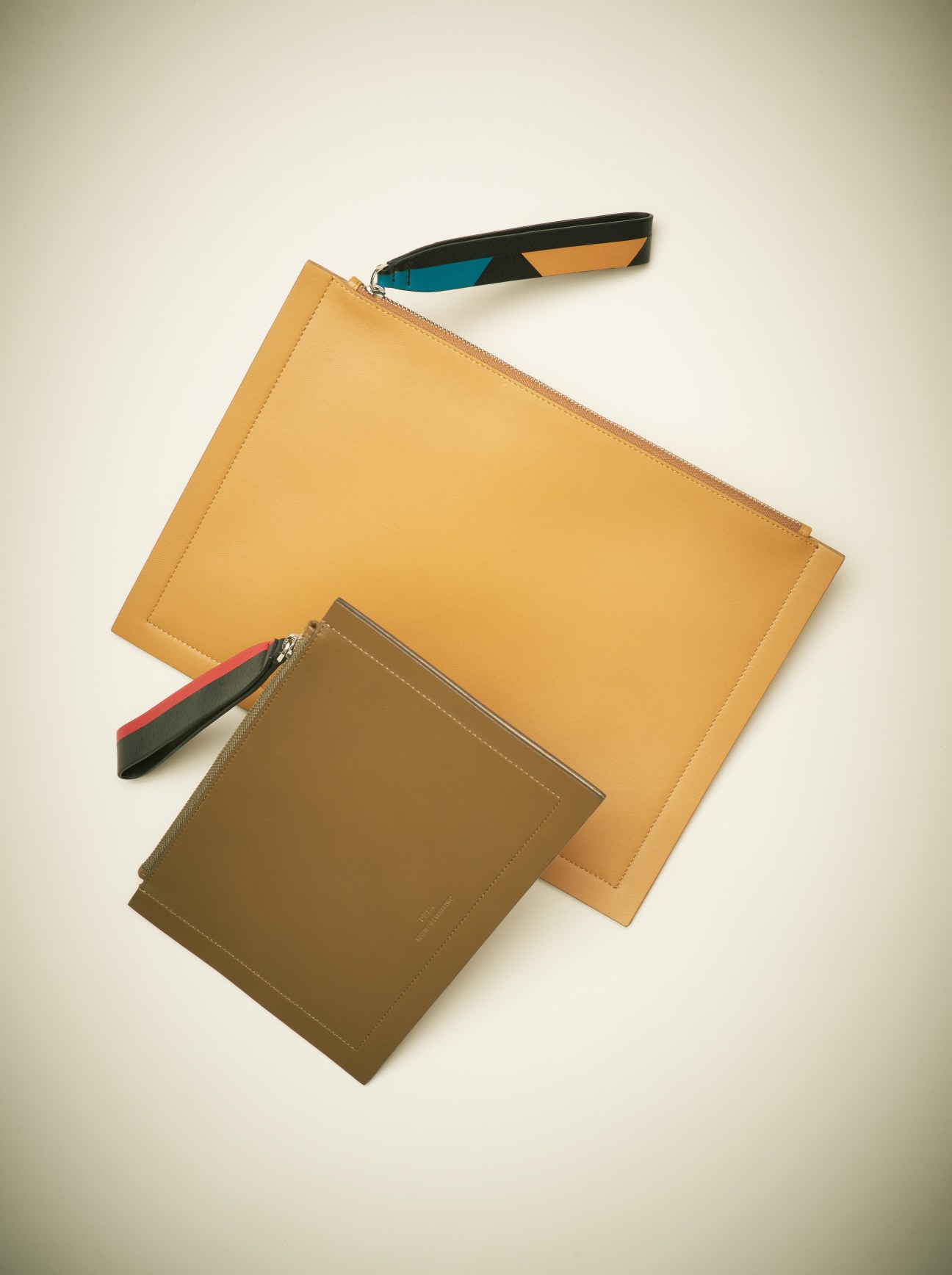 Desa 1972 clutches with tribal-patterned zips in mustard yellow and olive tones.