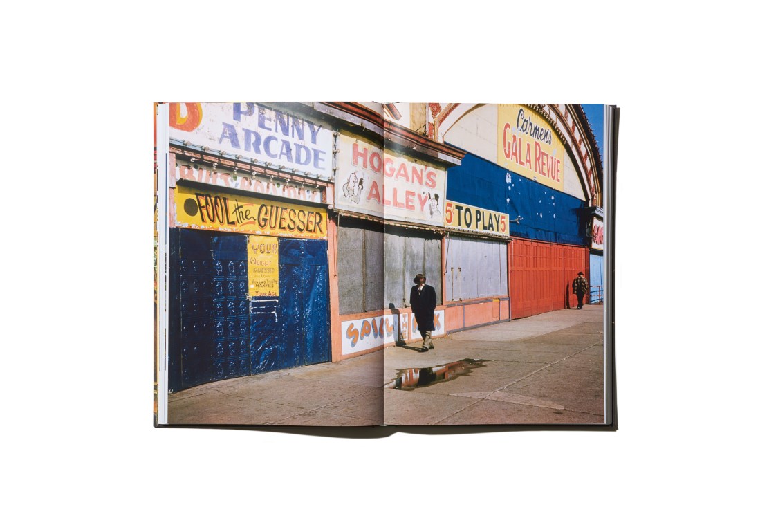 Open book spread showing Marvin E Newman's photograph of colorful vintage shop signs and storefronts in 1950s New York.