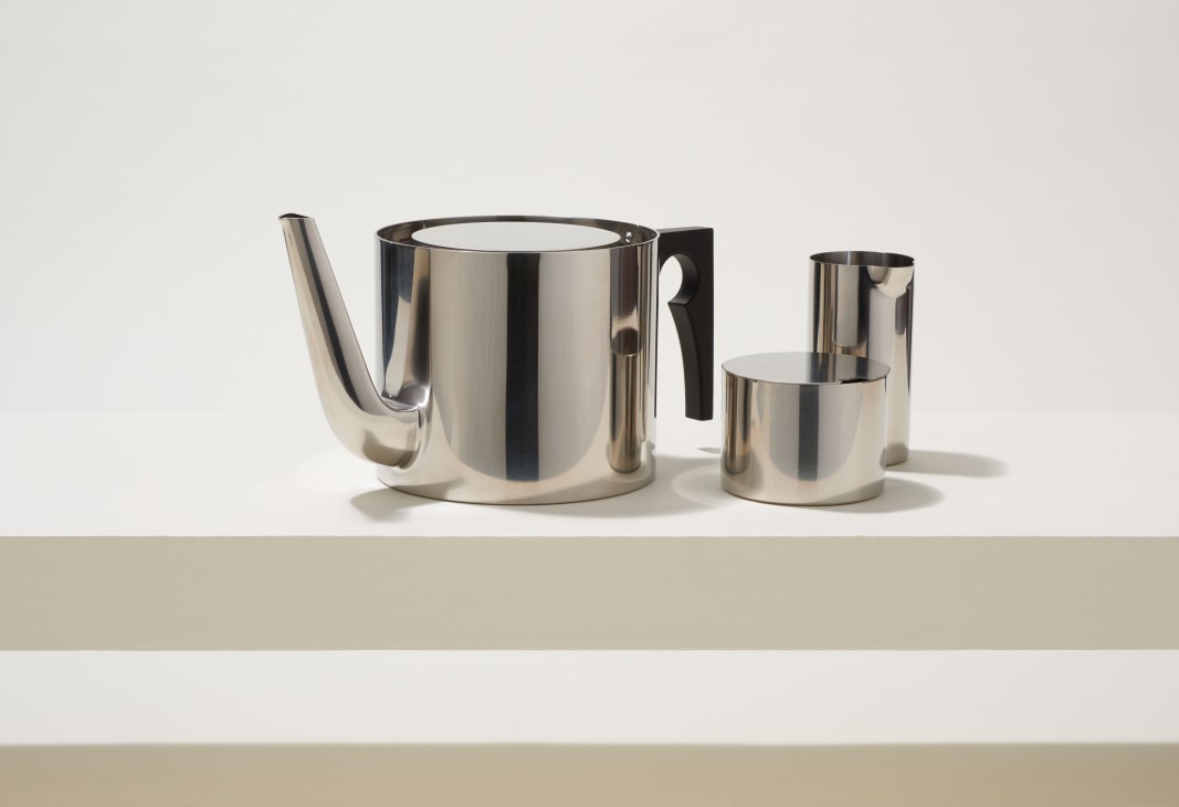 Stainless steel teapot with black handle and matching creamer by Stelton's AJ series design.