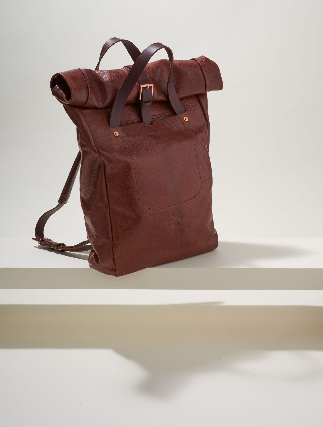 Burgundy leather roll-top backpack with dark straps and gold buckle detail by Billy Tannery.