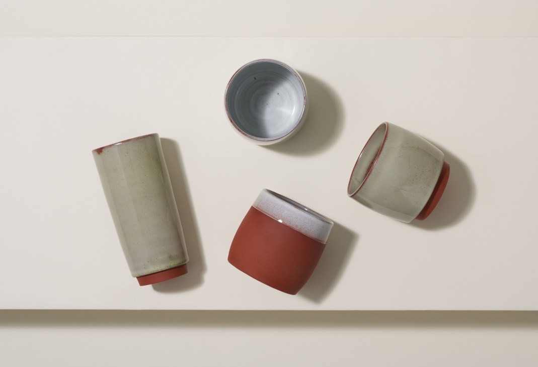 Four ceramic vessels by Reiko Kaneko in cream, white, and red glazes arranged on a neutral background.