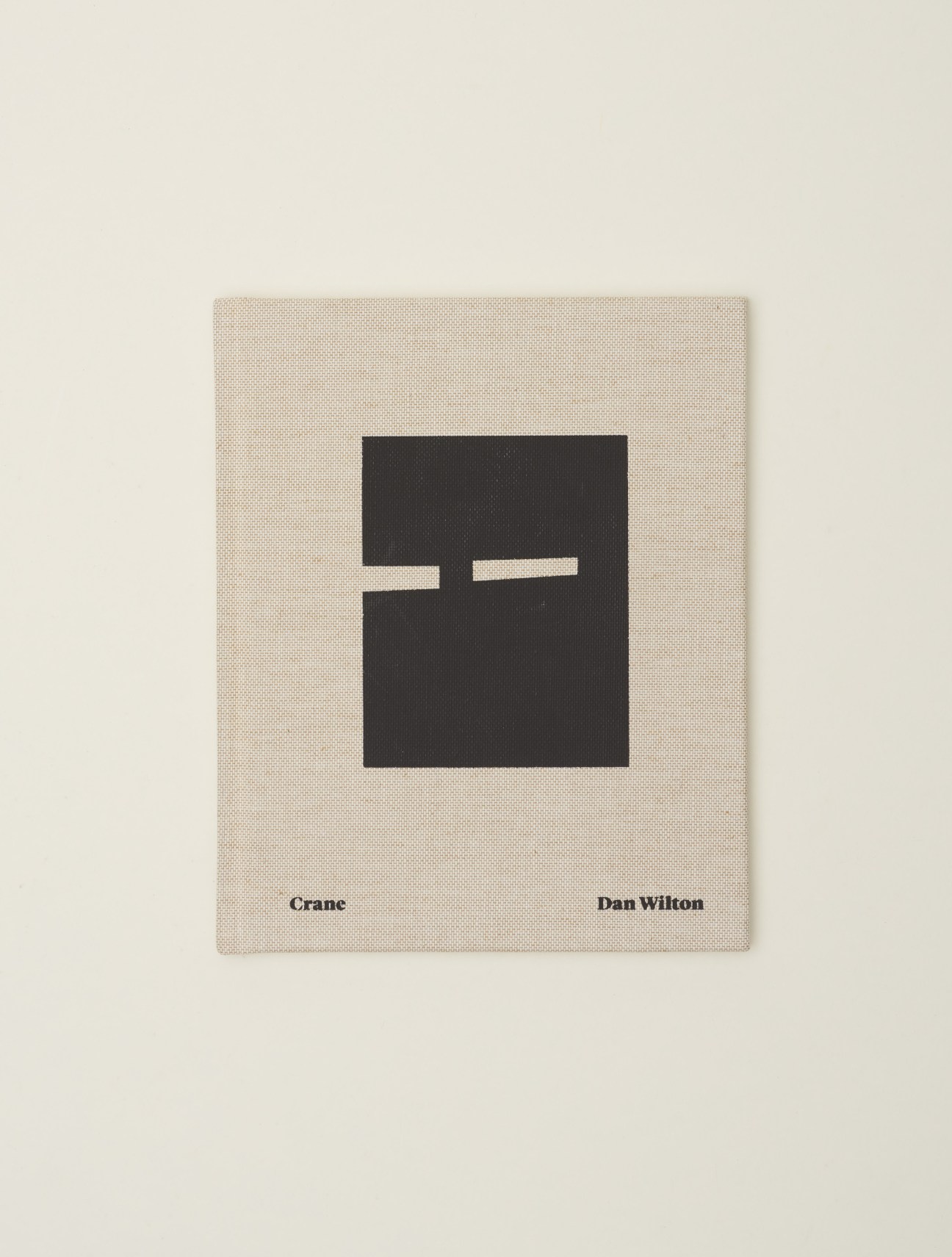 Cover of Crane photography book by Dan Wilton showing minimalist design with black shape on beige background