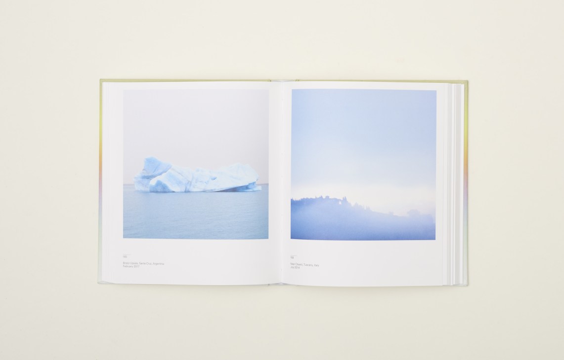 Open book displaying two landscape photographs with blue tones on white pages