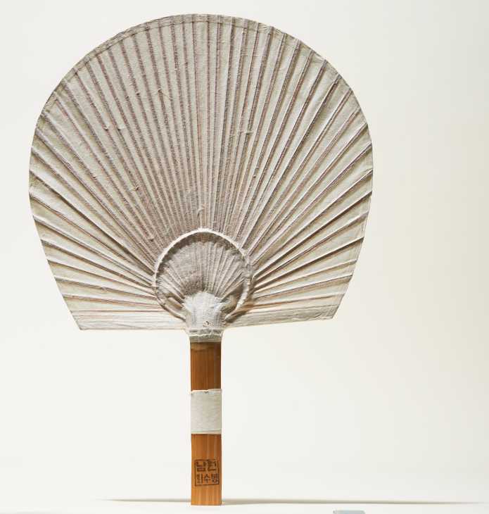 Traditional Korean hanji paper fan with bamboo handle featuring radiating pleats.