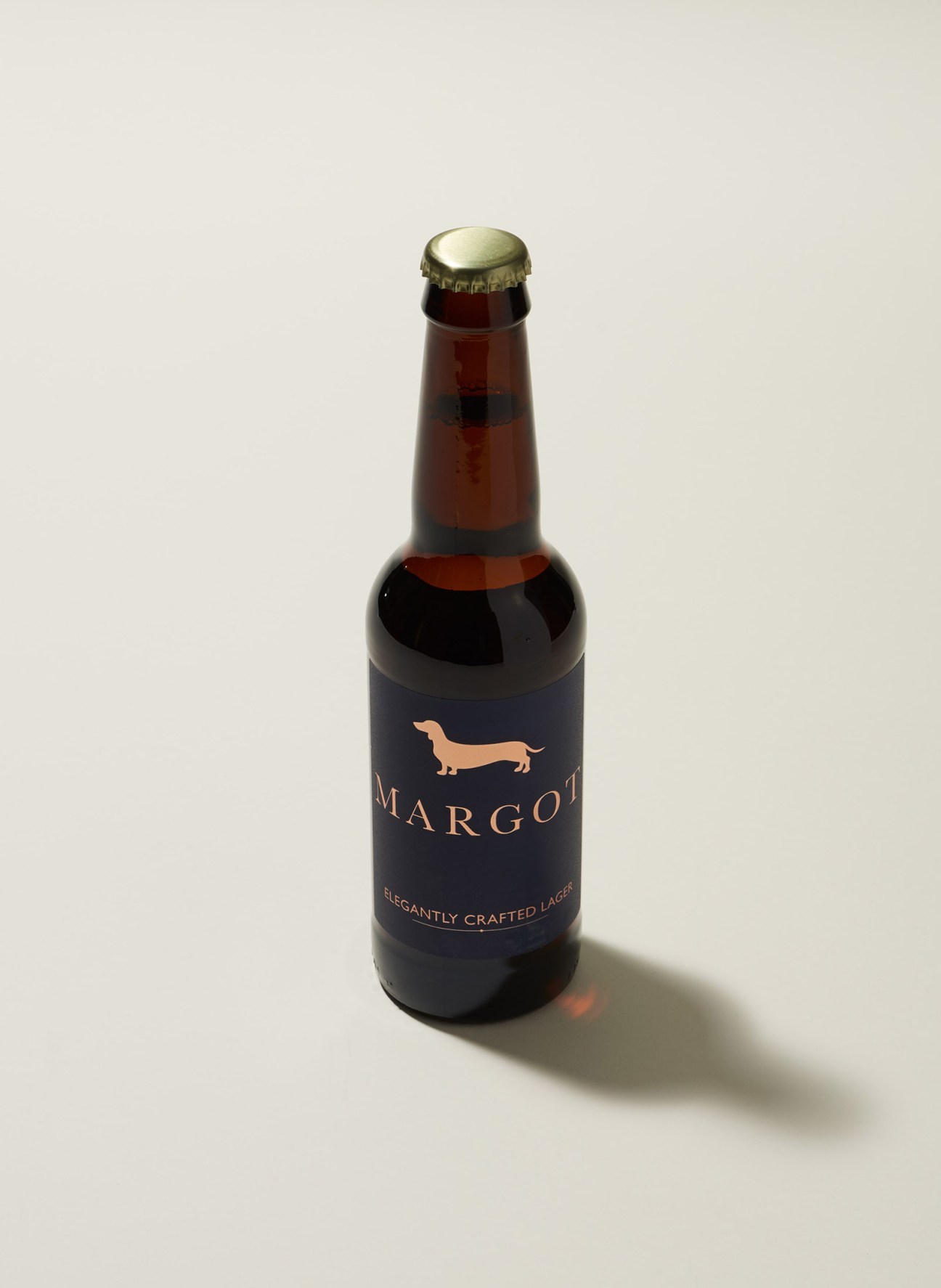 Margot lager beer bottle with golden dachshund silhouette on dark label.