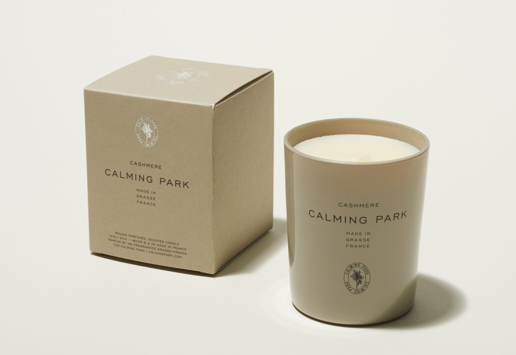 Calming Park cashmere candle in beige container with matching branded box.